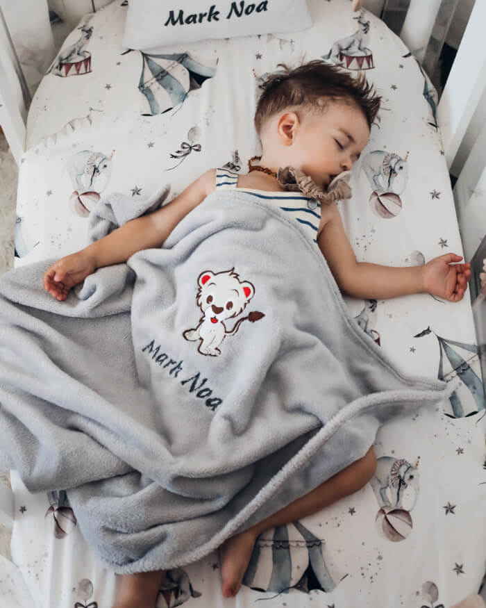 Zgodan dječak Mark Noa spava pokriven svojom personaliziranom dekicom.